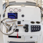 Fiberglass helm console with Simrad display, gauges, and stainless steel wheel with power knob